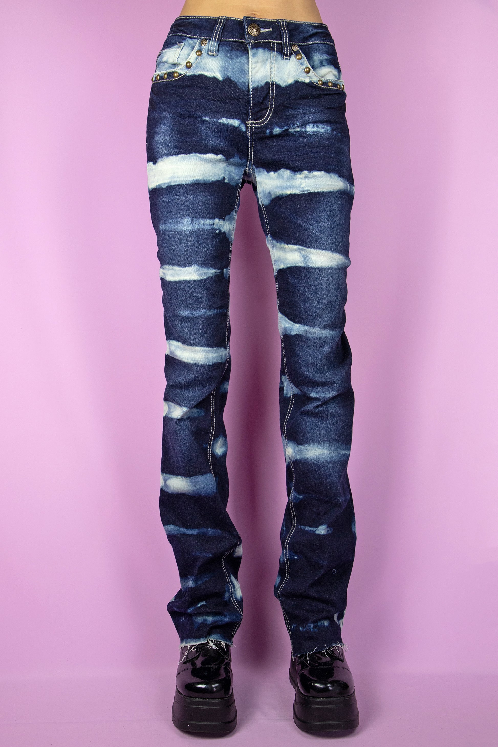 The Vintage Y2K Striped Bleach Jeans are straight stretch denim pants adorned with bleached stripes, featuring pockets and a raw hem. These iconic millennium cyber custom jeans from the 2000s are the perfect choice for festivals, raves, and clubbing.