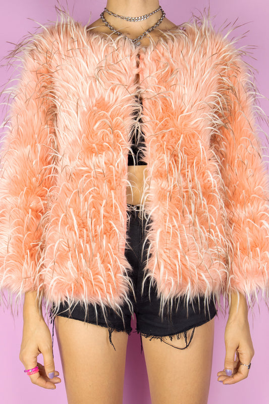 The Vintage 90s Orange Faux Fur Jacket is a salmon peach orange hue shaggy faux fur jacket with a hook closure. Cyber rave festival 1990s statement coat.