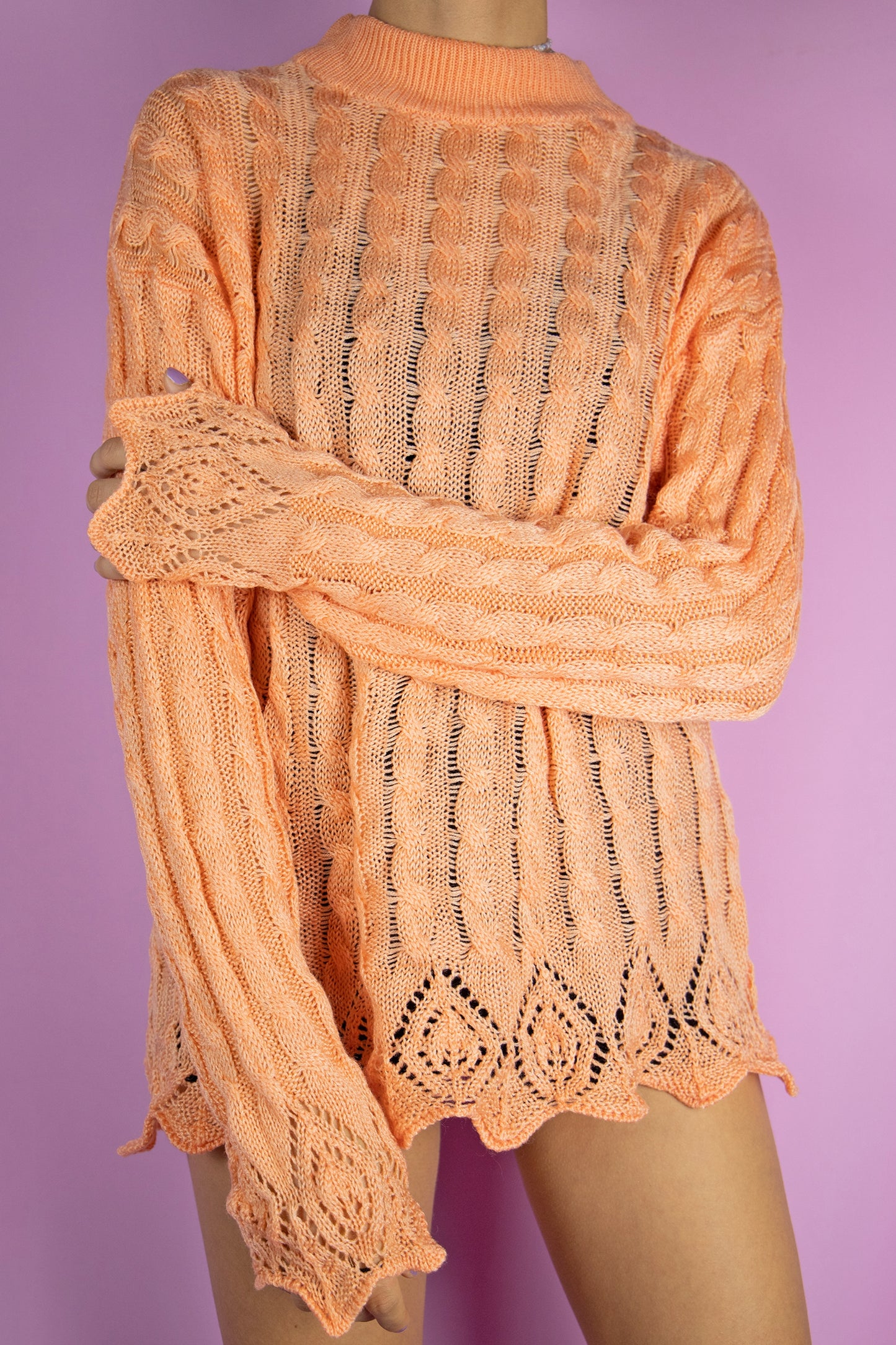 The Vintage 80’s Orange Cable Knit Sweater is a delightful pastel orange crocheted turtleneck sweater. Achieve a super cute oversized look with this lovely boho fairy grunge jumper from the 1980s.