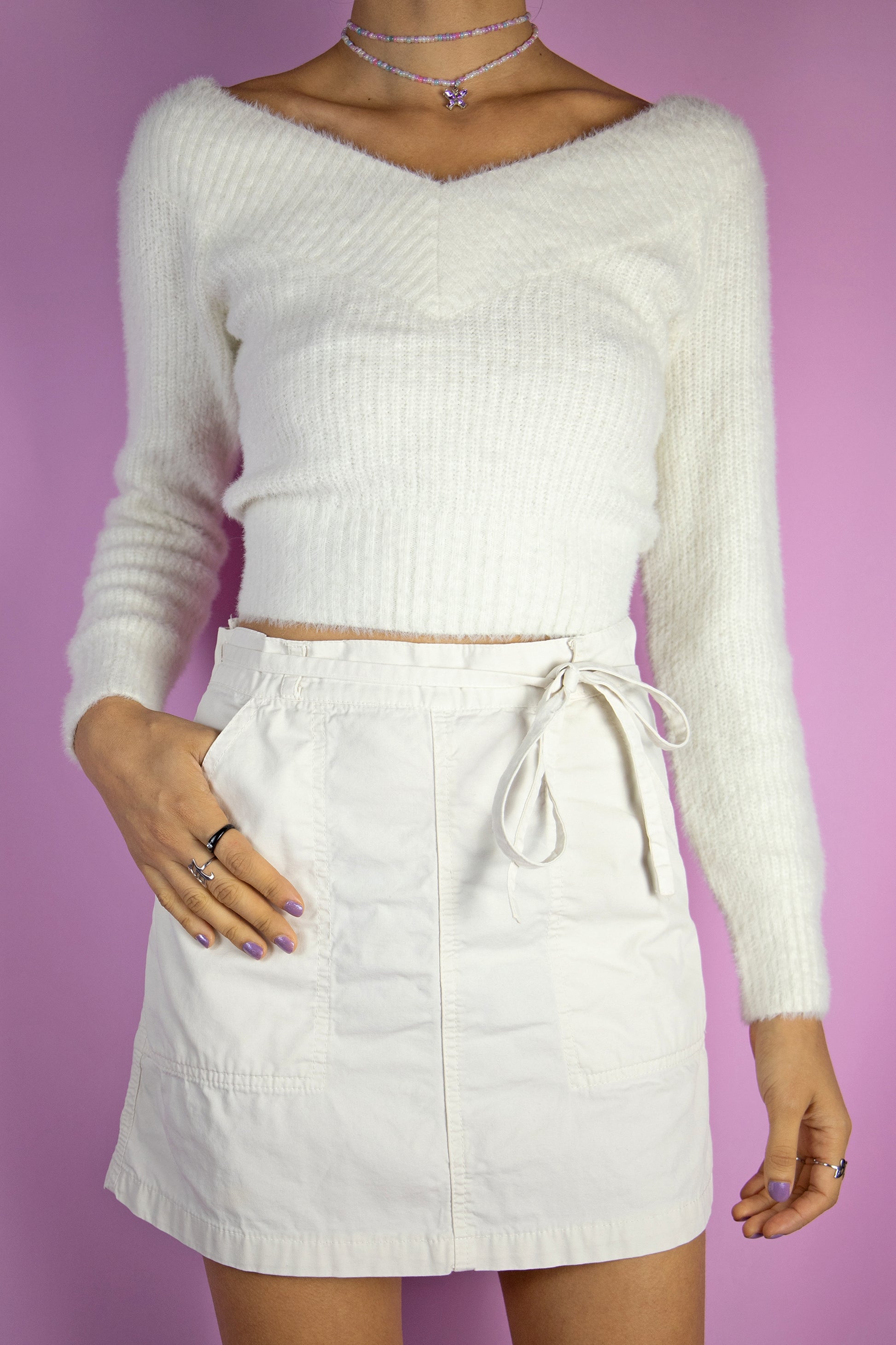 The Vintage 90's White Wrap Mini Skirt is a beige-white wrap mini skirt with a side tie and pockets. Super cute utility subversive cyber grunge style, circa the 1990s.