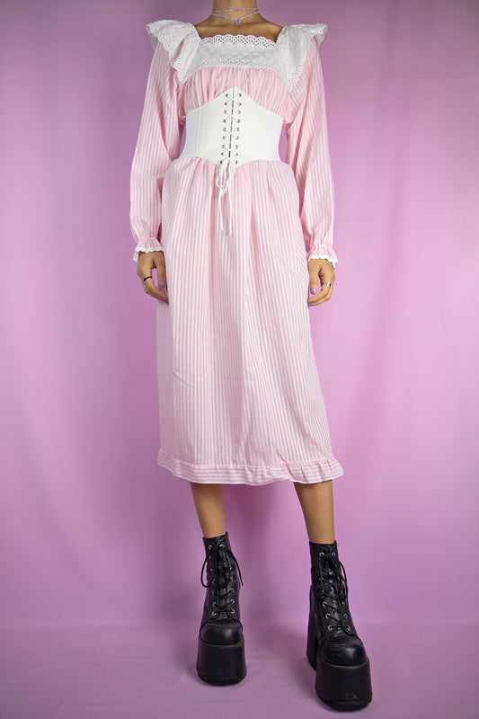 The Vintage 80s Light Pink Nightgown Dress is a romantic cottagecore-inspired pastel pink striped midi dress lounge sleepwear with long sleeves, a square neckline with a white lace collar, and a ruffle hem.