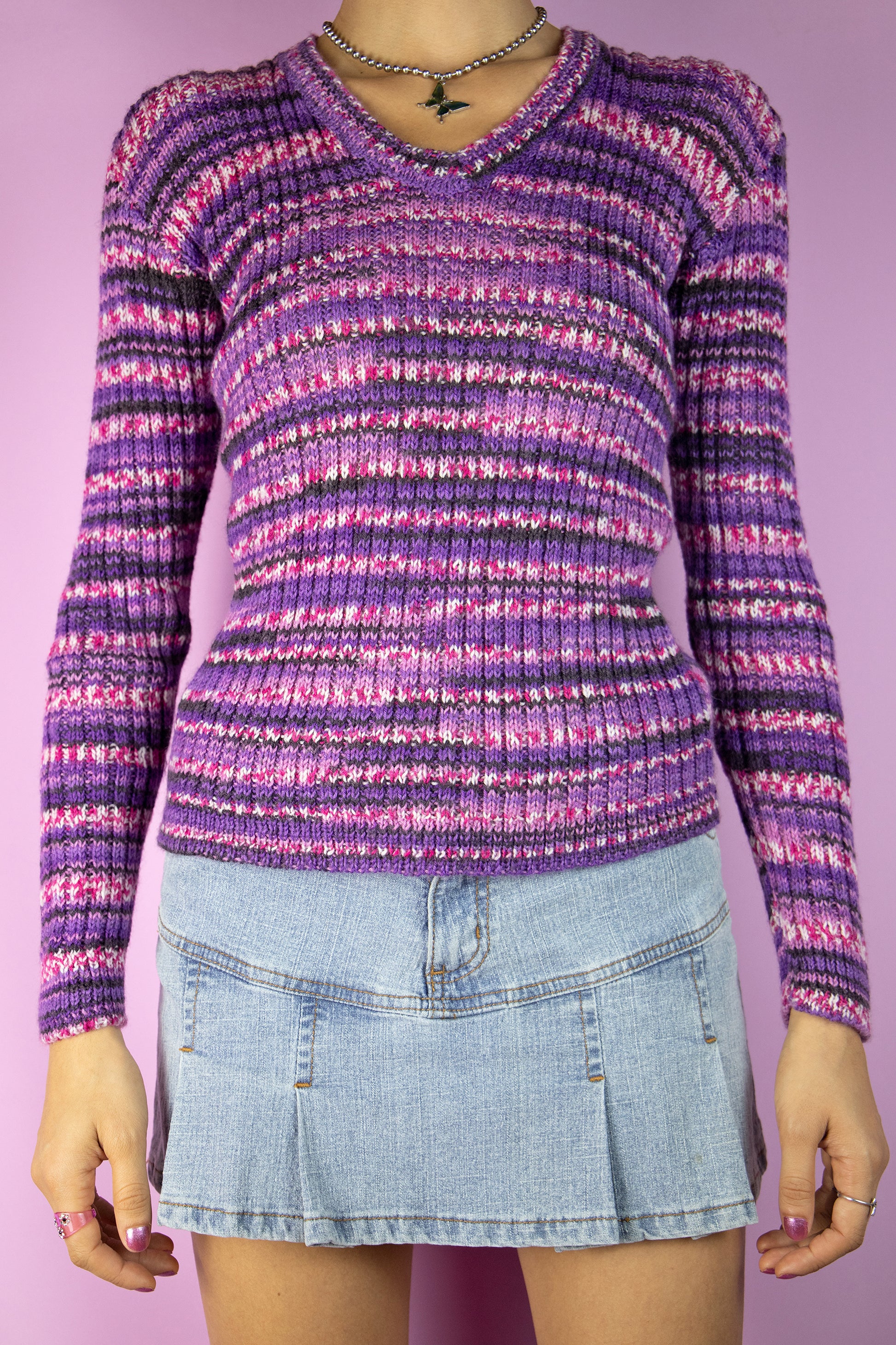 The Vintage 90's Purple Striped Ribbed Sweater is a super cute cyber knit pullover with ribbed details and pink, lilac, and purple stripes, showcasing the iconic style of the 1990s.