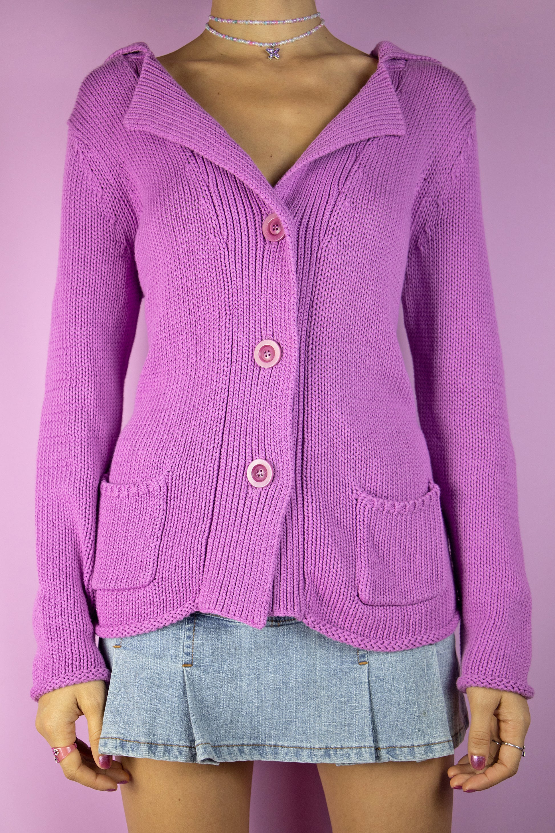The Vintage Y2K Pink Lilac Knit Cardigan is a lovely cyber boho sweater from the 2000s, featuring a pastel purple lilac pink chunky knit, collar, buttons, and pockets.
