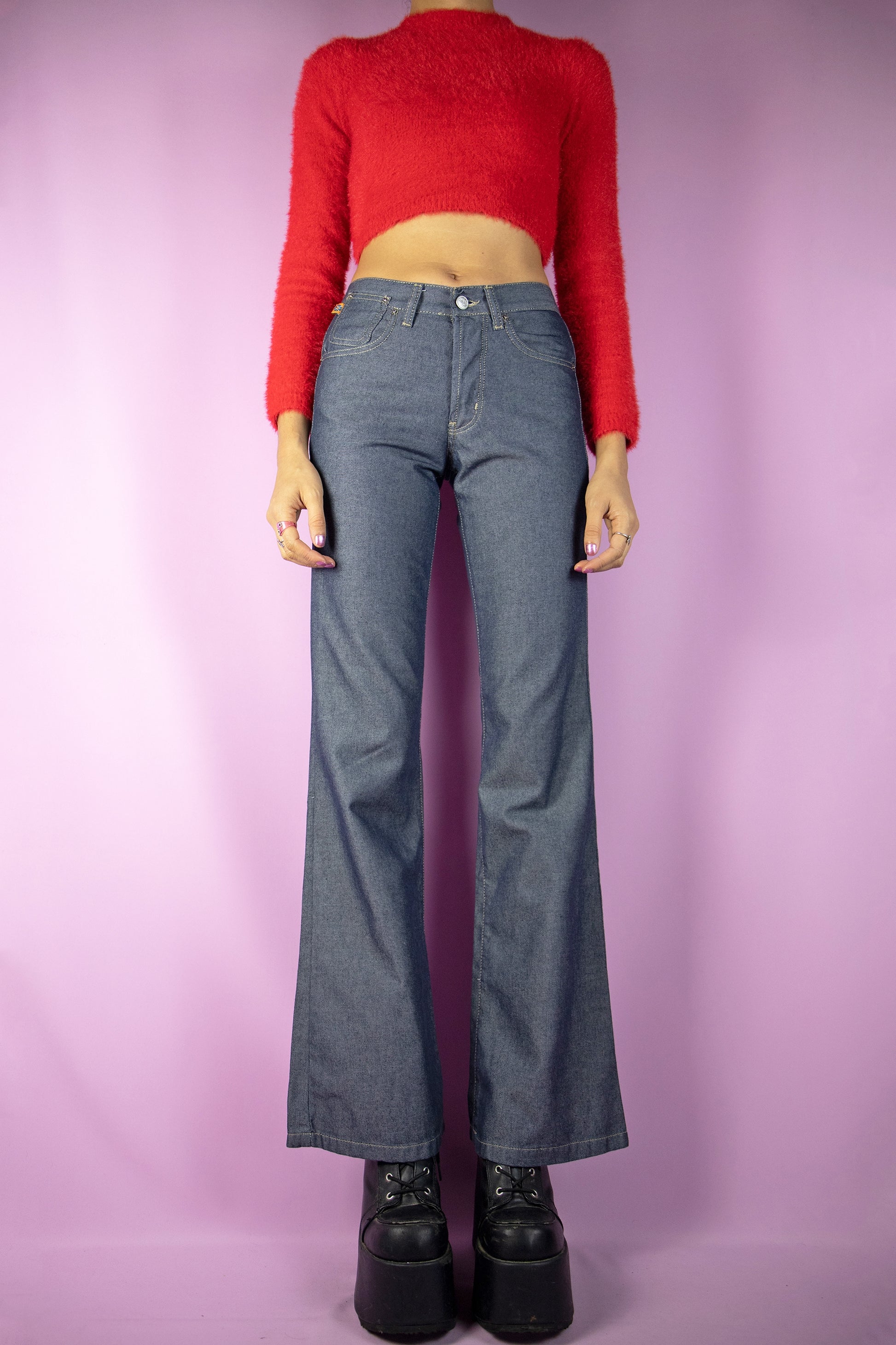 The Y2K Dark Mid Rise Flare Jeans are dark gray-blue mid-rise wide-leg flared pants with button closure and pockets. Super cute cyber grunge 2000s denim trousers.