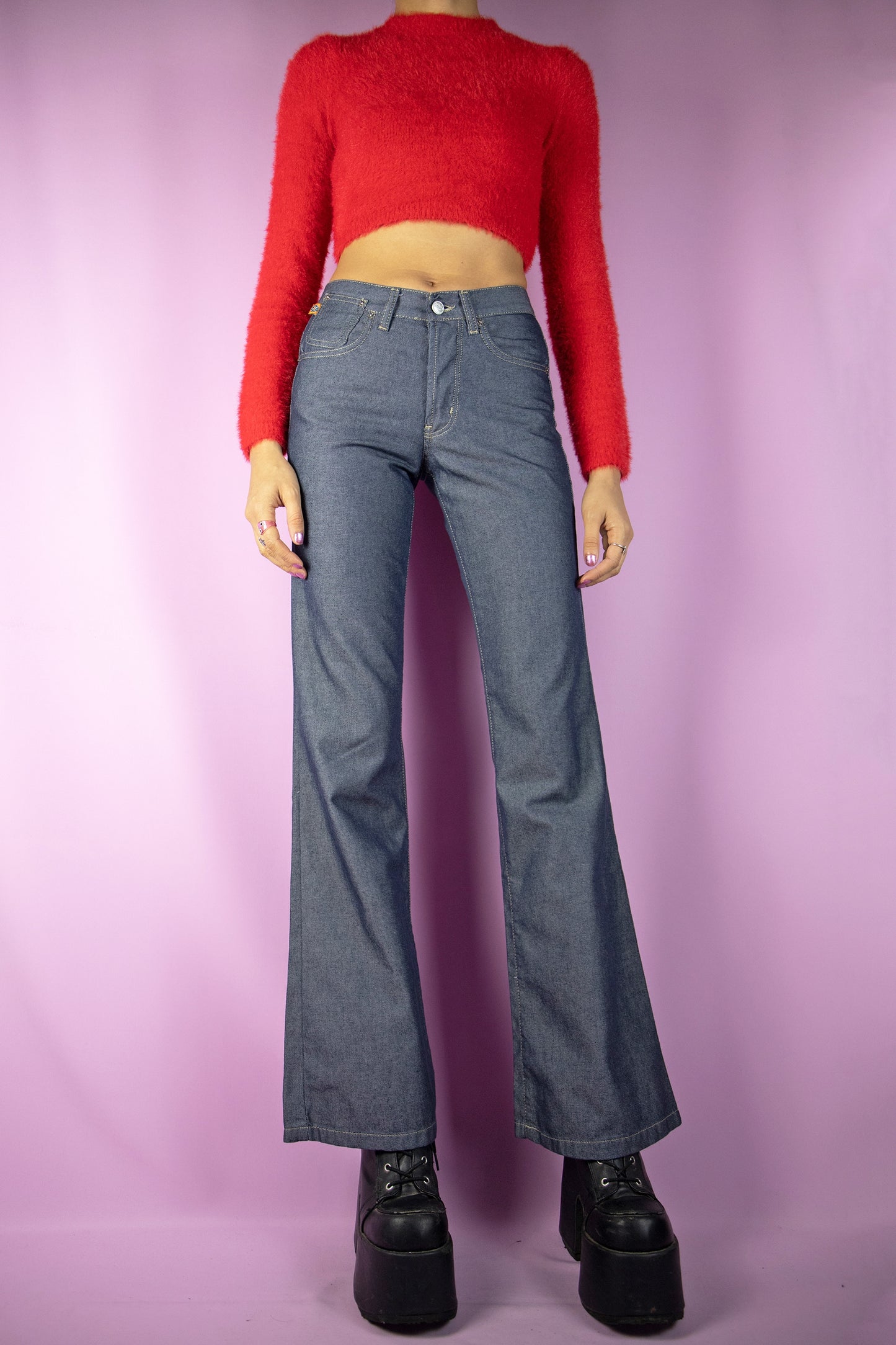 The Y2K Dark Mid Rise Flare Jeans are dark gray-blue mid-rise wide-leg flared pants with button closure and pockets. Super cute cyber grunge 2000s denim trousers.