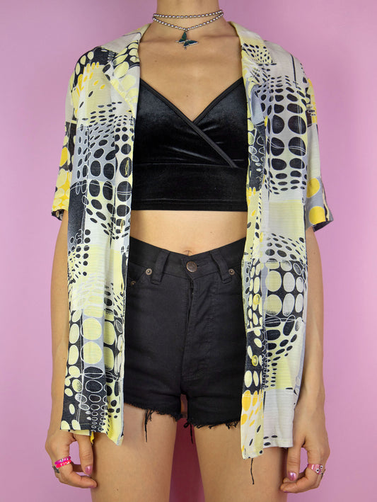 The Vintage 90s Abstract Print Shirt is a summer festival style yellow, black and white short sleeve geometric crazy pattern collared blouse with button closure.