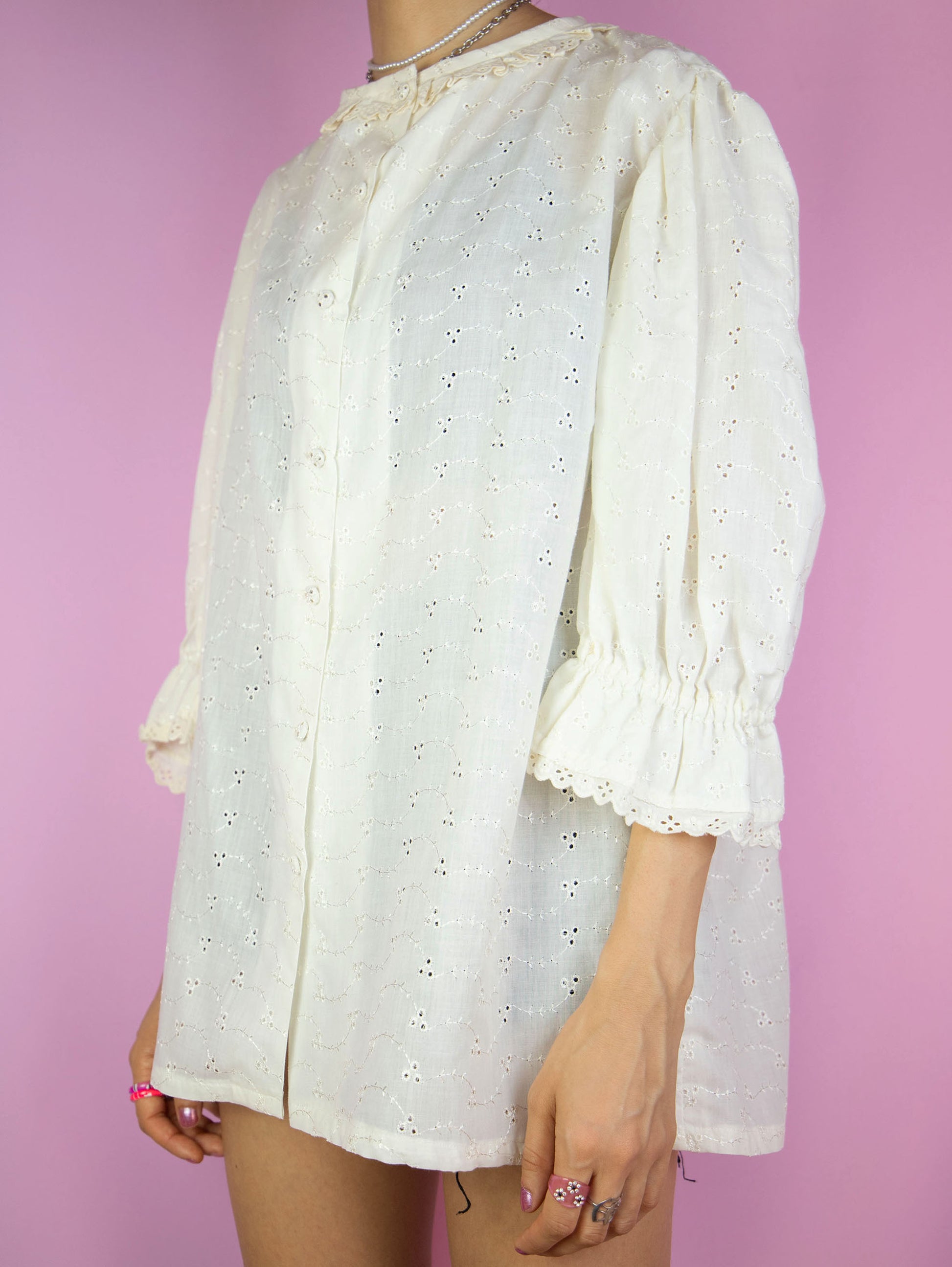The Vintage 90s Cottage Prairie Cream Blouse is a white top with a ruffled neckline, lace trim and floral embroidery, buttons and puff sleeves. Looks cute when worn oversized. Lovely boho fairy 1990s summer shirt.