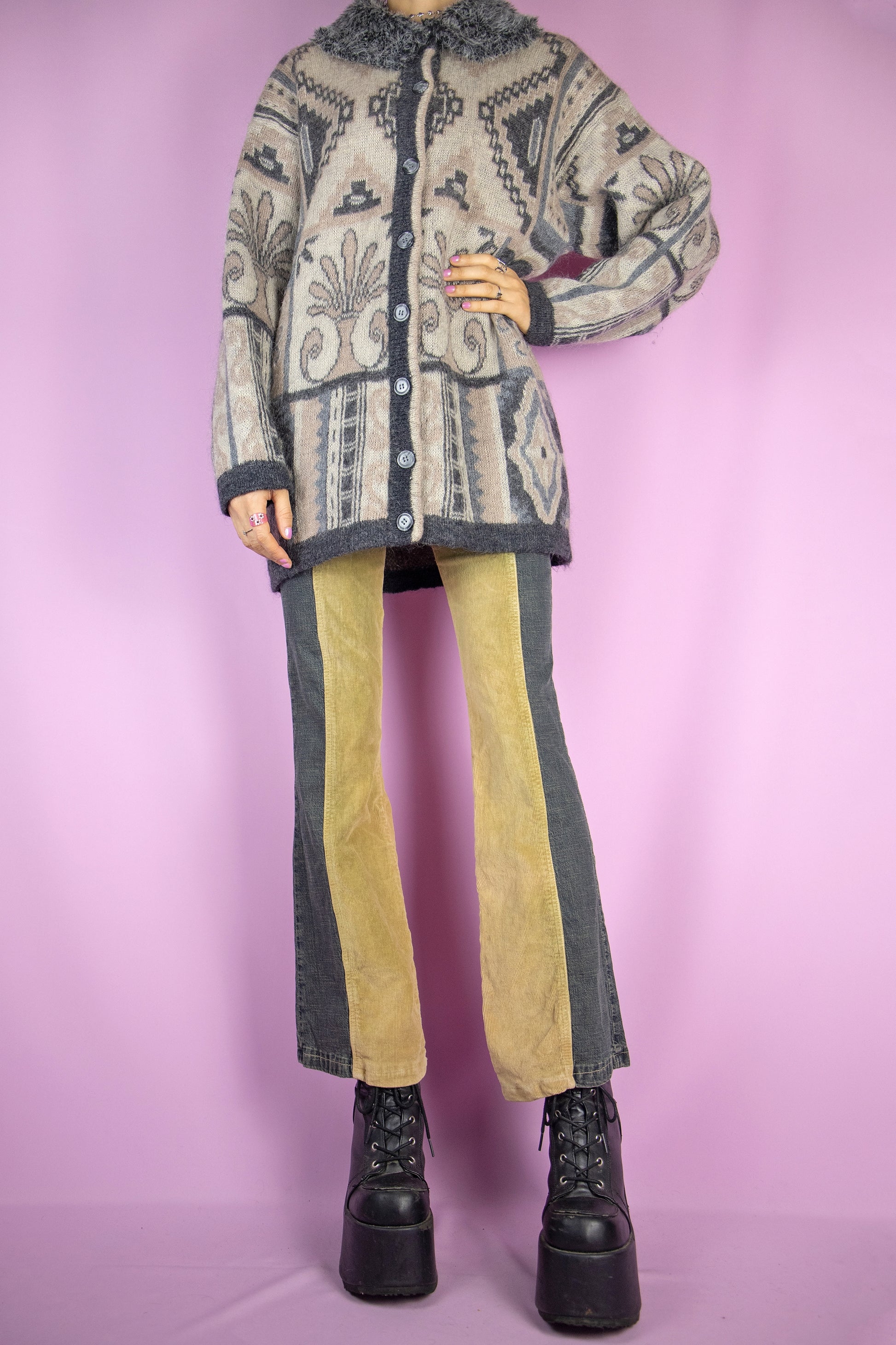The Vintage 90s Faux Fur Collar Cardigan is a long, oversized-style cardigan featuring a geometric abstract pattern. Crafted from a mohair wool blend, it showcases buttons and a plush faux fur collar. Perfect for any casual winter outfit.