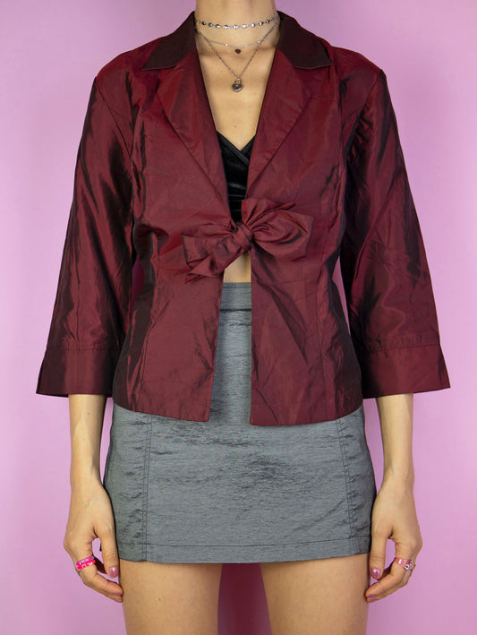 The Y2K Maroon Tie Bolero Jacket is an iridescent shimmering burgundy red half-sleeve top that ties in the front. Gorgeous elegant party night 2000s shirt.