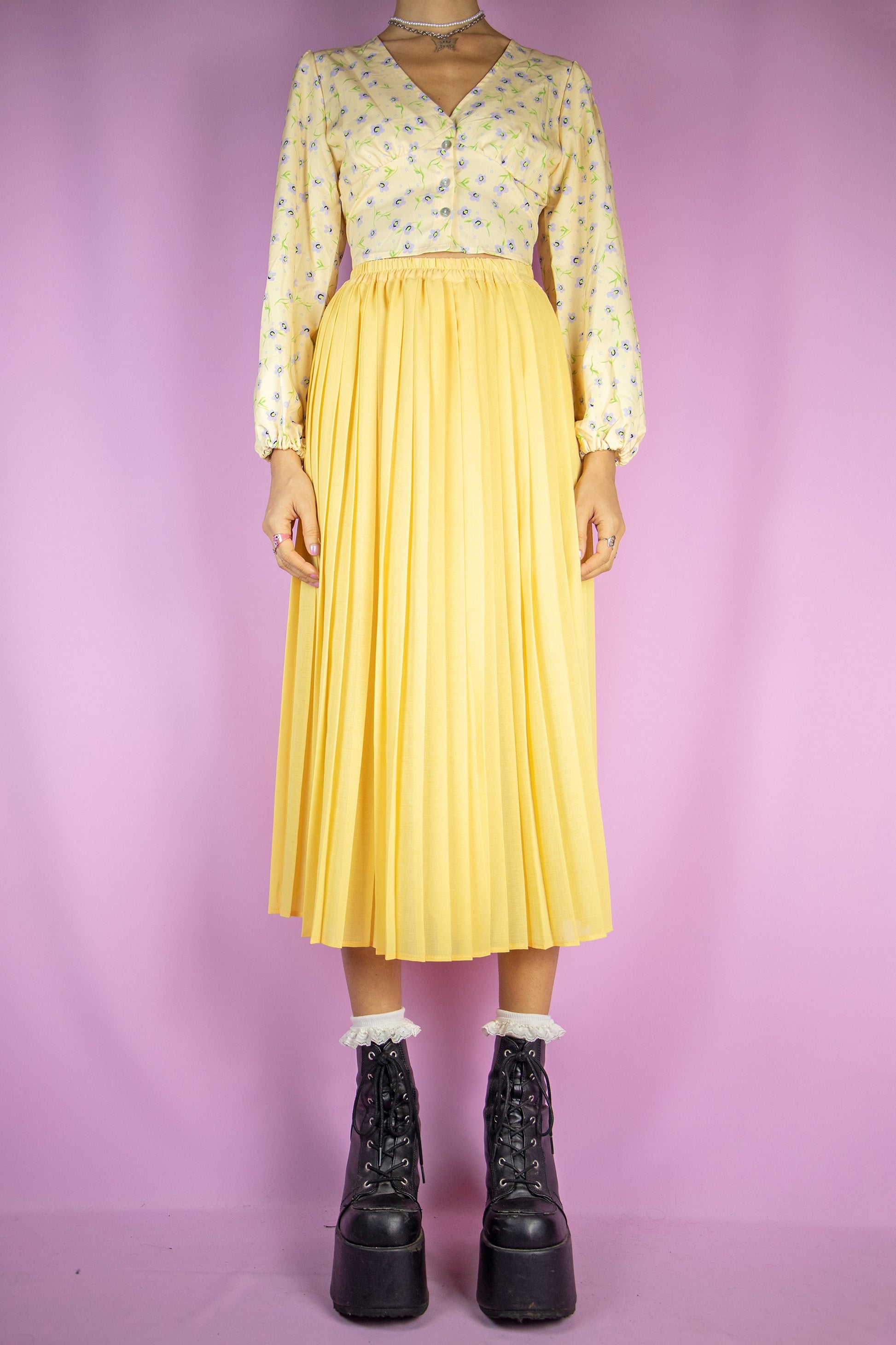The Vintage 90s Yellow Pleated Midi Skirt is a long pleated yellow skirt with an elasticated waist. Classic preppy 1990s maxi skirt.