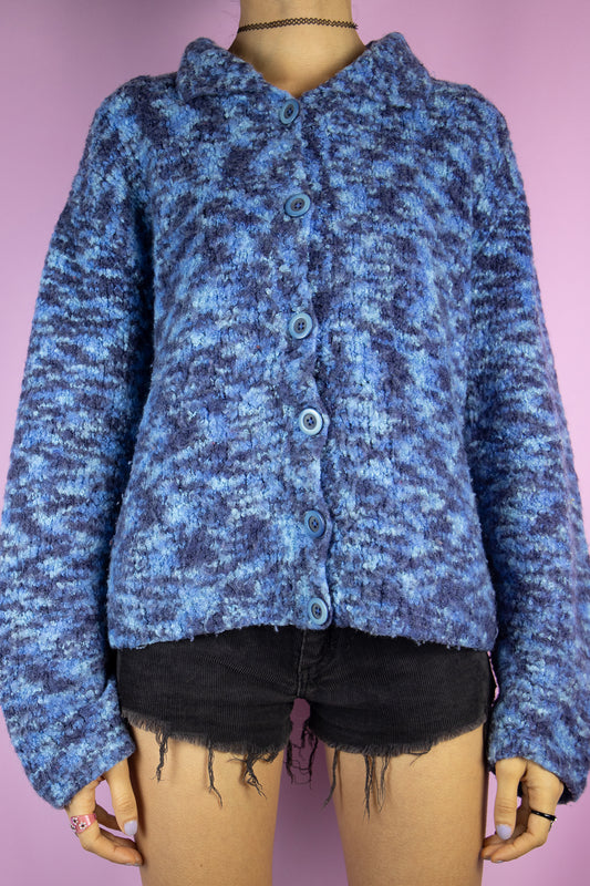 The Vintage 90s Boho Blue Cardigan is a chunky knit blue cardigan with a collar and buttons. Retro grunge 1990s winter sweater.