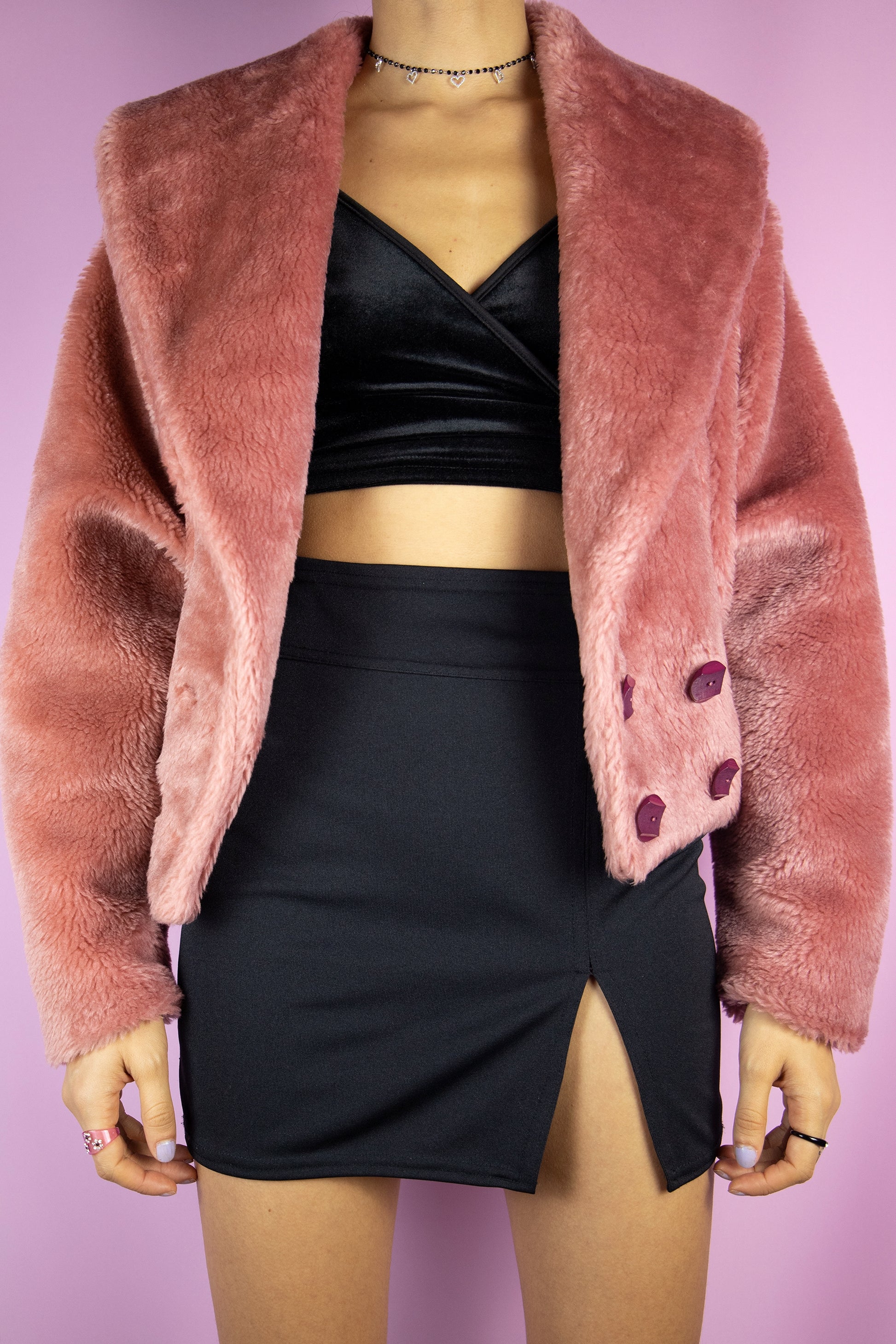 The Vintage 90s Pink Faux Fur Jacket is a pastel dusty pink faux fur jacket with a collar, buttons, pockets and elasticated waist. Romantic boho retro 1990s winter statement coat.