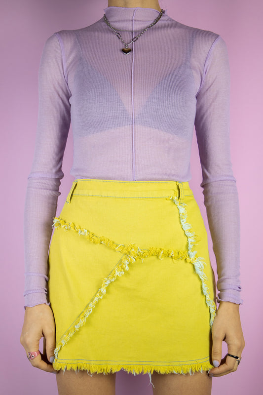 The Y2K Cyber Yellow Mini Skirt is a vintage stretchy yellow asymmetric skirt with frayed raw-edge detail. Subversive grunge 2000s mini skirt.
