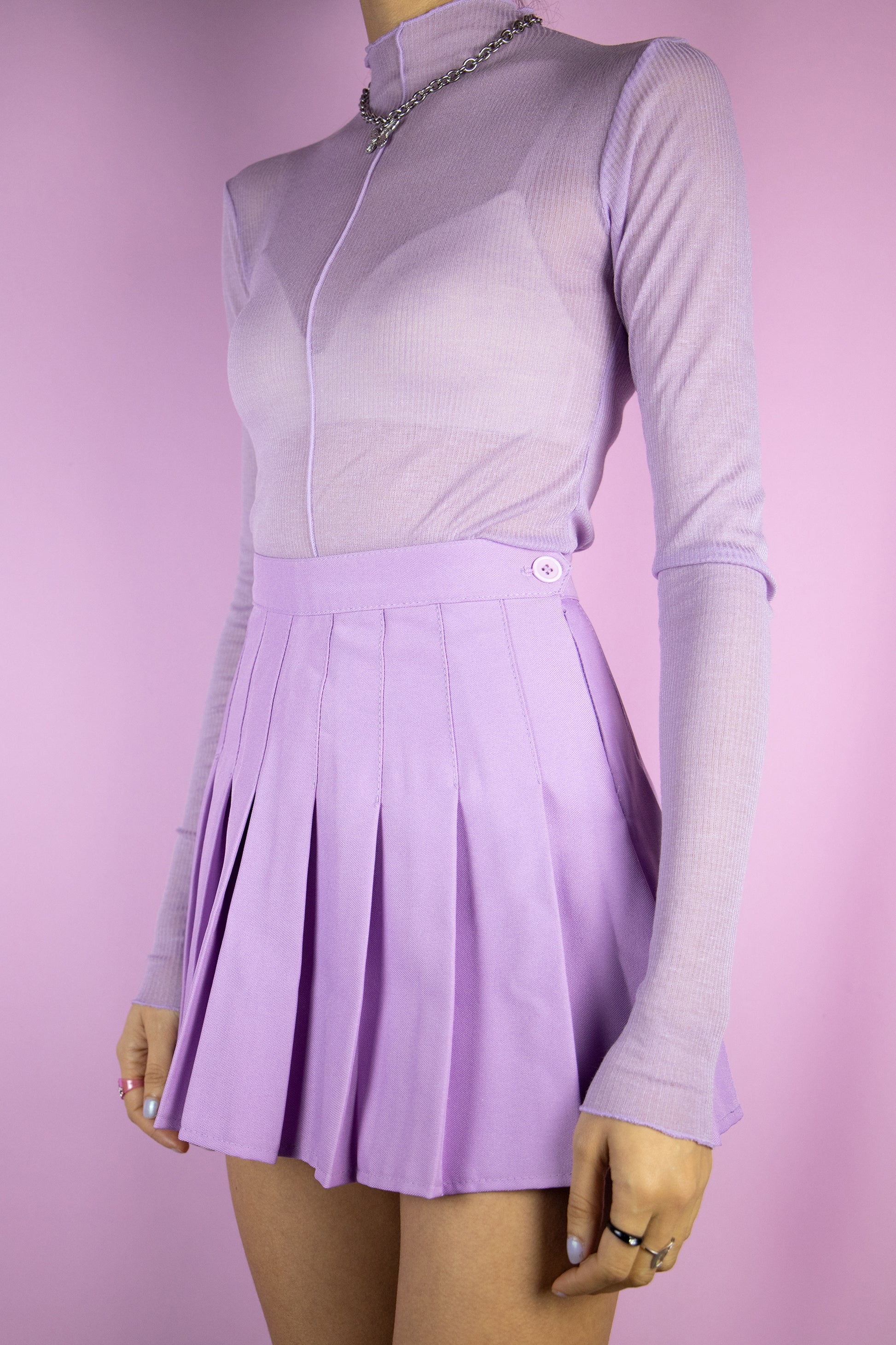 The Y2K Lilac Pleated Mini Skirt is a vintage pastel light purple pleated skirt with a side zipper closure. Classic preppy 2000s cyber mini skirt.