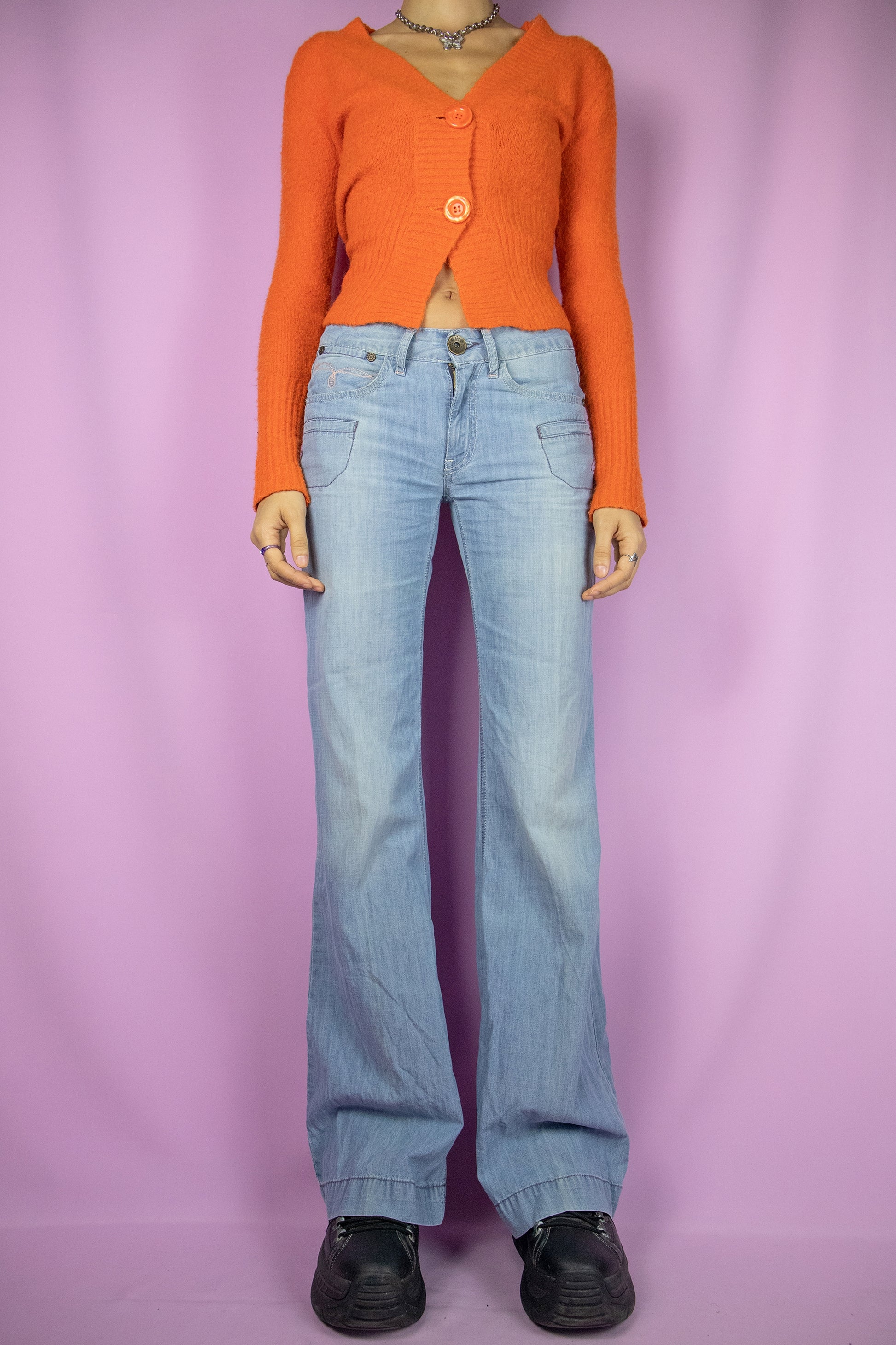 The Y2K Flare Low Rise Jeans are vintage 2000s light blue denim wide-leg pants with pockets and a zipper closure.