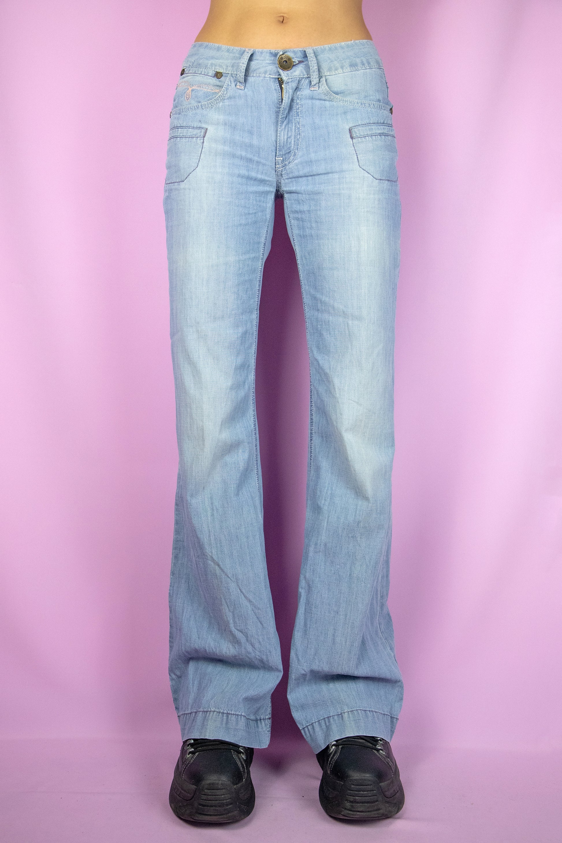 The Y2K Flare Low Rise Jeans are vintage 2000s light blue denim wide-leg pants with pockets and a zipper closure.
