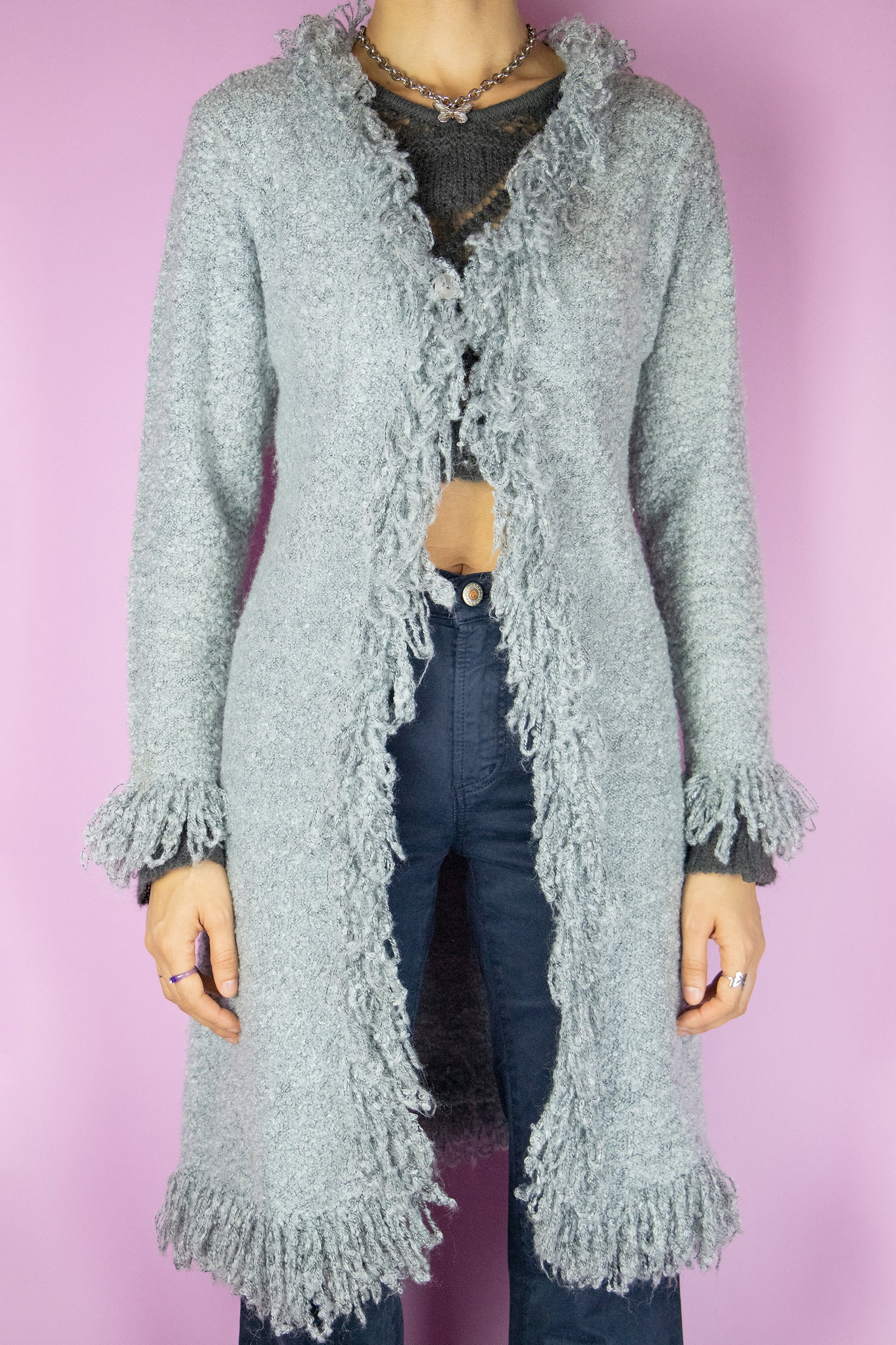 The Y2K Gray Penny Lane Cardigan is a vintage long shaggy knit cardigan with a one button closure and fringe trim at the neckline and cuffs. Cyber fairy grunge 2000s boho duster jacket.