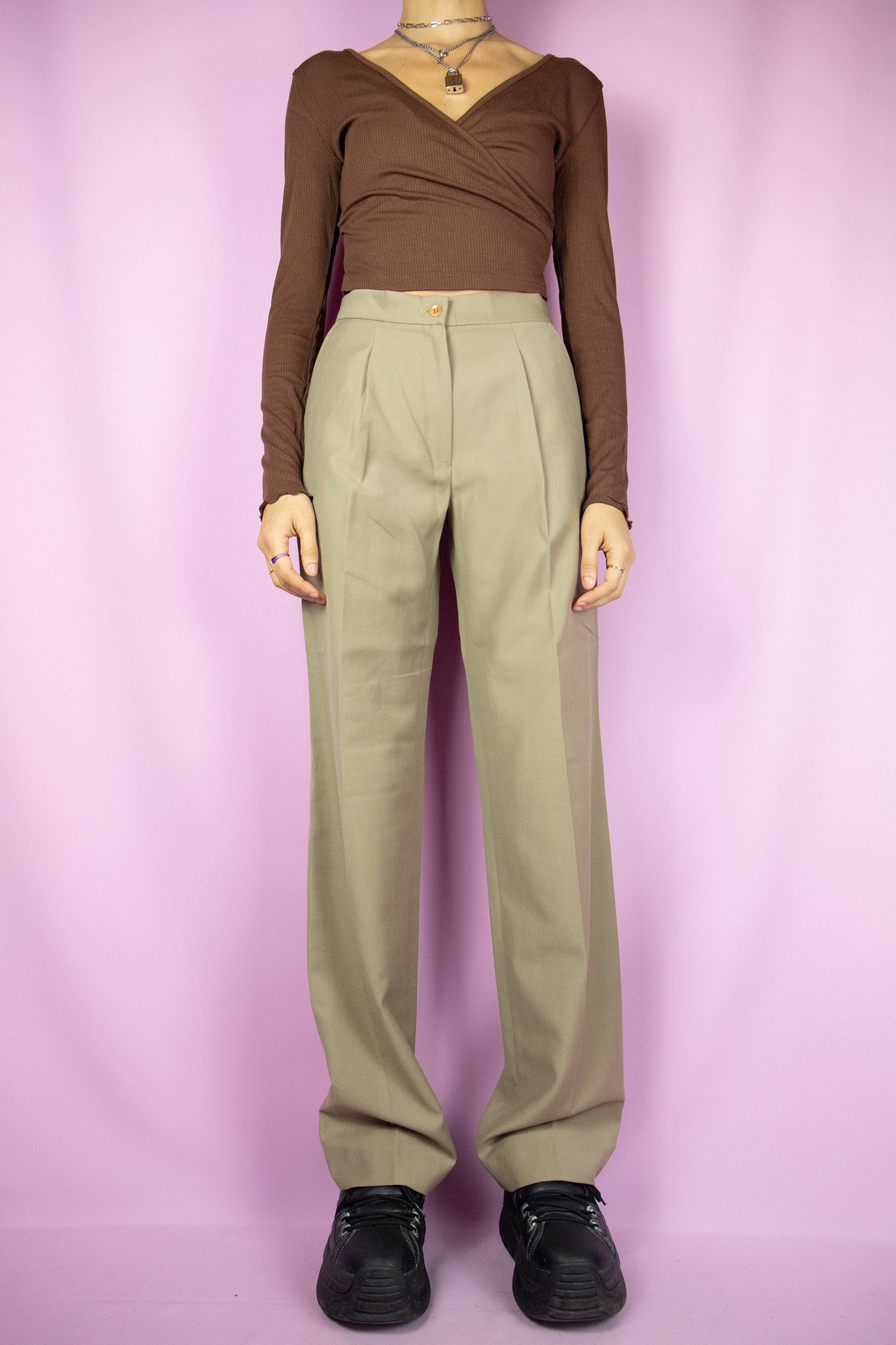 The Vintage 90s Beige Pleated Pants are beige wide pants with pleats, a zipper closure and pockets. Elegant classic tailored 1990s office pleated tapered trousers.