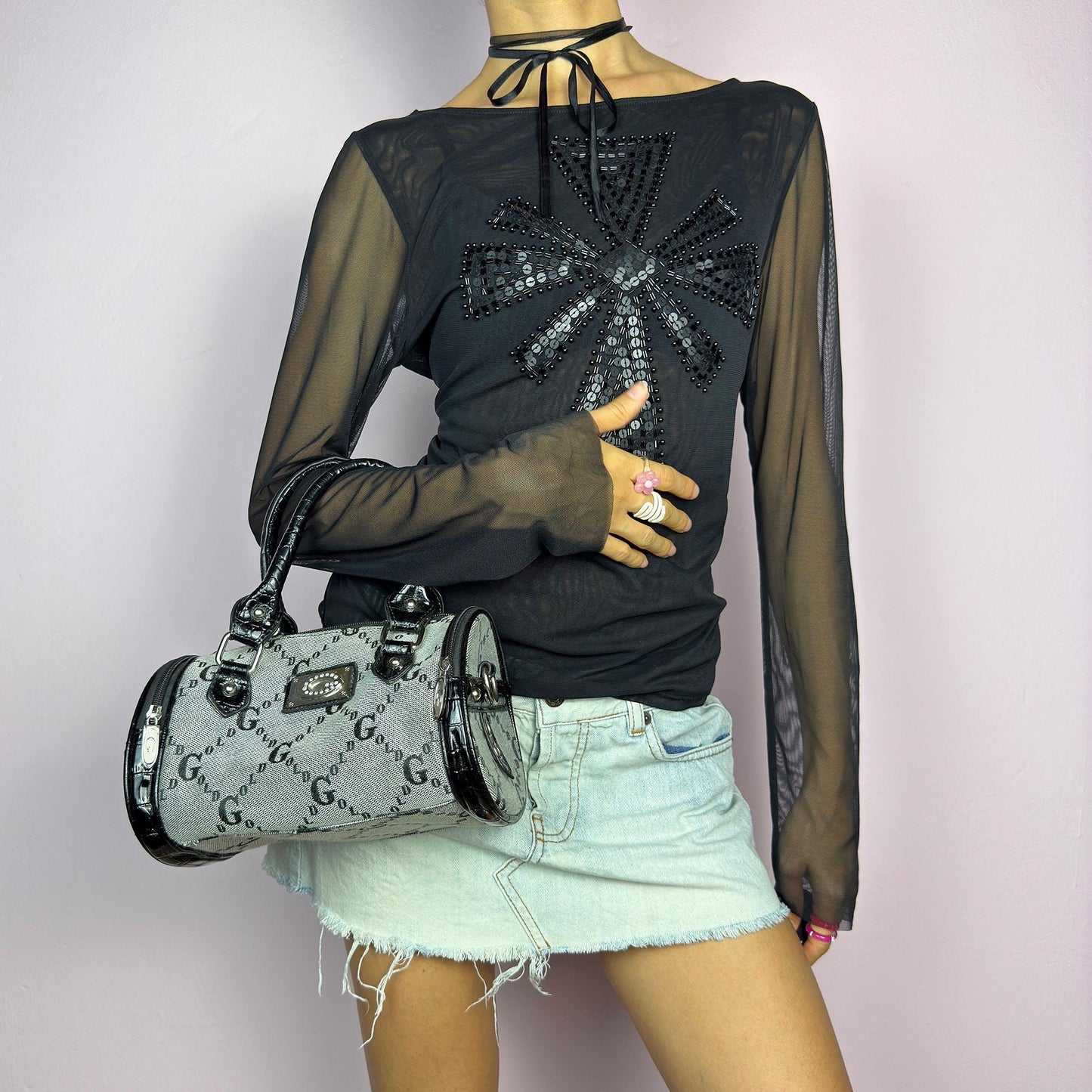 The Y2K Monogram Mini Duffel Bag is a stylish vintage 2000s accessory. Featuring a structured silhouette with an all-over monogram print, sleek black faux patent leather accents, and silver hardware. It includes dual top handles. adult world shop
